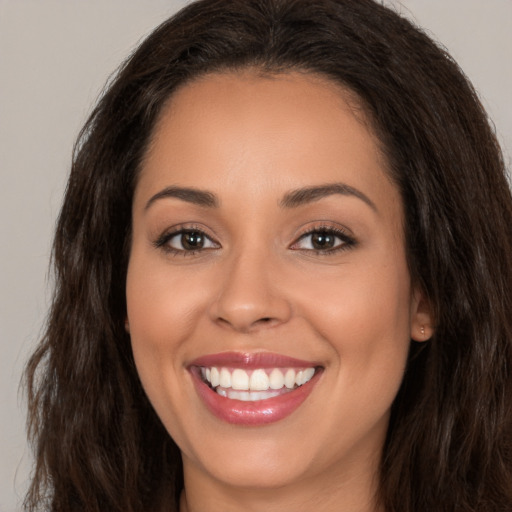 Joyful white young-adult female with long  brown hair and brown eyes