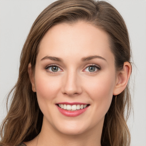 Joyful white young-adult female with long  brown hair and blue eyes