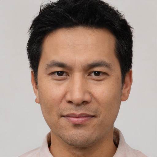 Joyful asian adult male with short  black hair and brown eyes