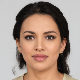 Joyful latino young-adult female with medium  brown hair and brown eyes