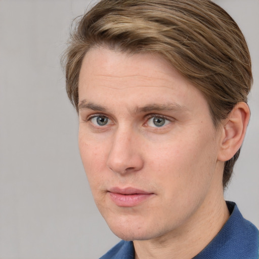 Joyful white young-adult male with short  brown hair and blue eyes