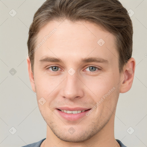 Joyful white young-adult male with short  brown hair and grey eyes