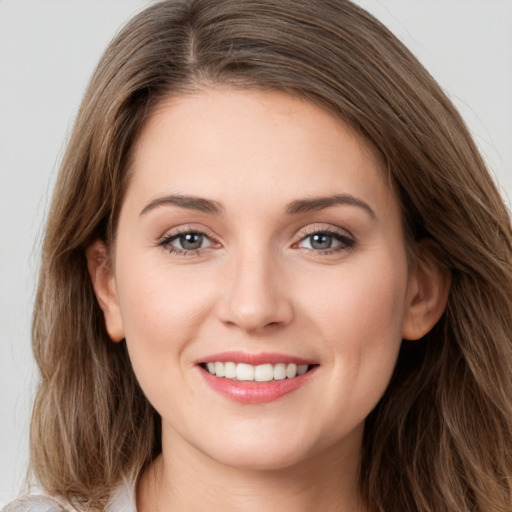 Joyful white young-adult female with long  brown hair and green eyes