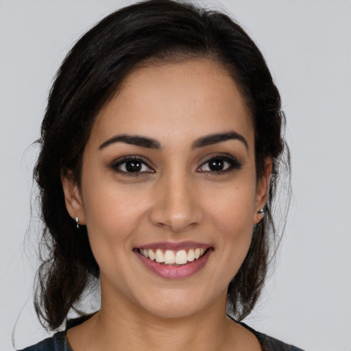 Joyful latino young-adult female with medium  brown hair and brown eyes