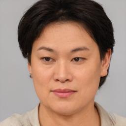 Joyful asian young-adult female with short  brown hair and brown eyes