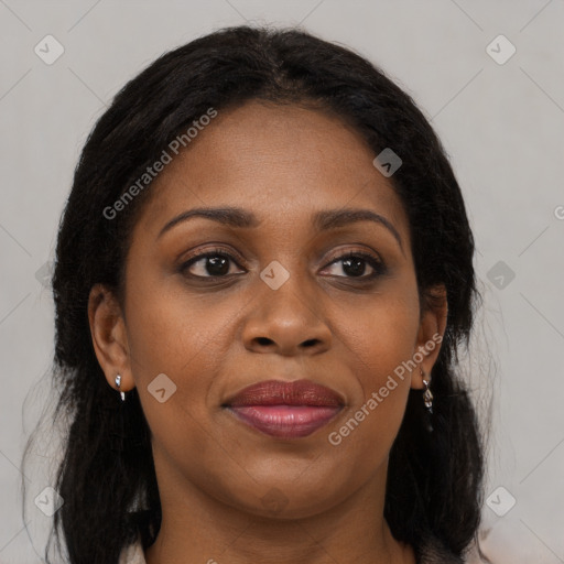 Joyful black adult female with long  brown hair and brown eyes