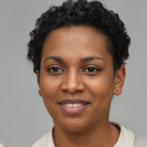 Joyful black young-adult female with short  black hair and brown eyes
