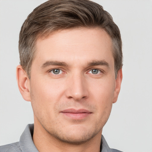 Joyful white young-adult male with short  brown hair and grey eyes