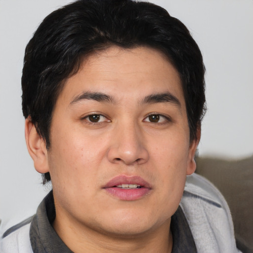 Joyful asian young-adult male with short  brown hair and brown eyes