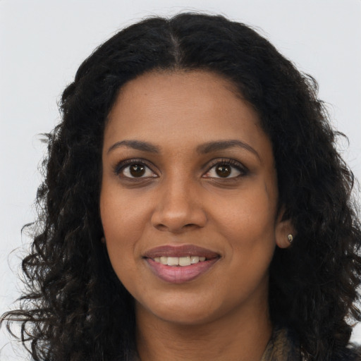 Joyful black young-adult female with long  brown hair and brown eyes
