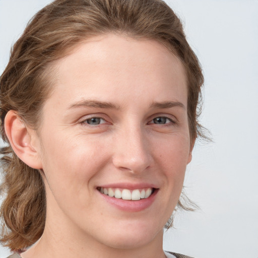 Joyful white young-adult female with medium  brown hair and blue eyes