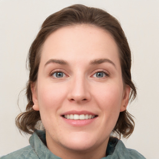 Joyful white young-adult female with medium  brown hair and blue eyes