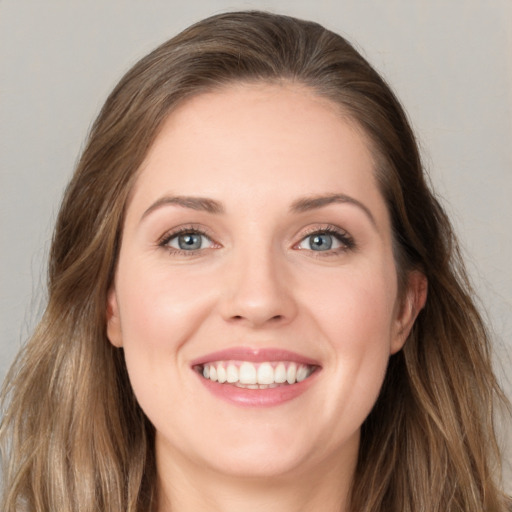 Joyful white young-adult female with long  brown hair and blue eyes