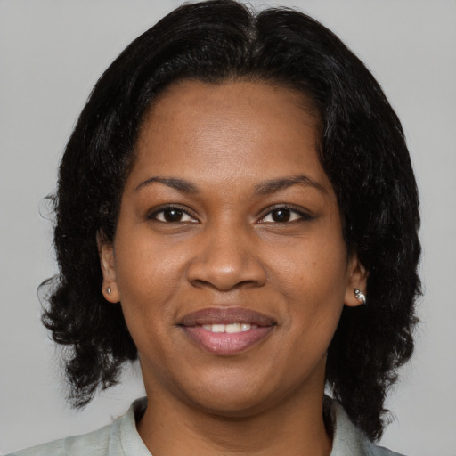Joyful black adult female with medium  brown hair and brown eyes