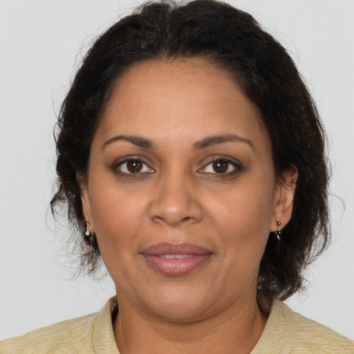 Joyful latino adult female with medium  brown hair and brown eyes