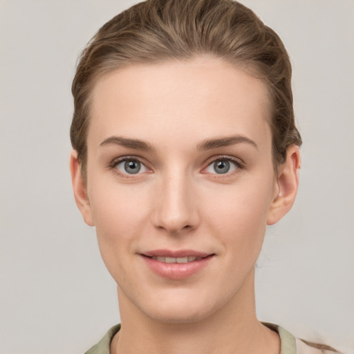 Joyful white young-adult female with short  brown hair and grey eyes