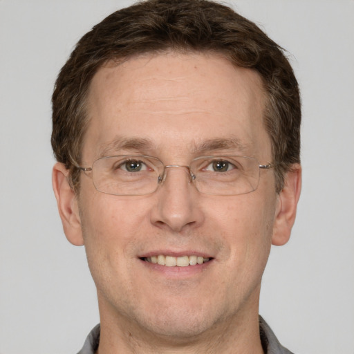 Joyful white adult male with short  brown hair and grey eyes