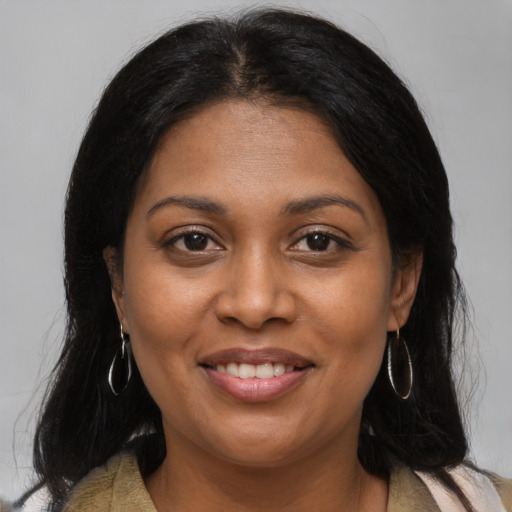 Joyful black young-adult female with long  brown hair and brown eyes