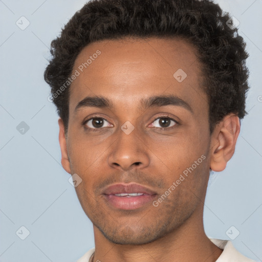 Joyful black young-adult male with short  brown hair and brown eyes