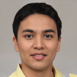 Joyful latino young-adult male with short  brown hair and brown eyes