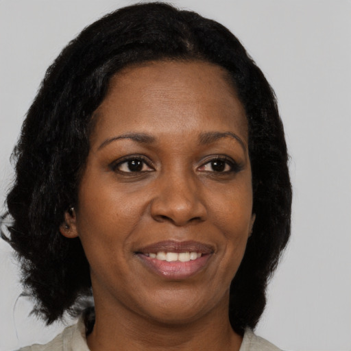 Joyful black young-adult female with long  black hair and brown eyes