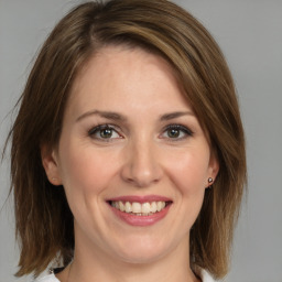 Joyful white young-adult female with medium  brown hair and grey eyes