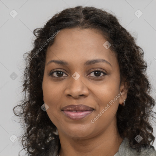 Joyful black young-adult female with long  brown hair and brown eyes