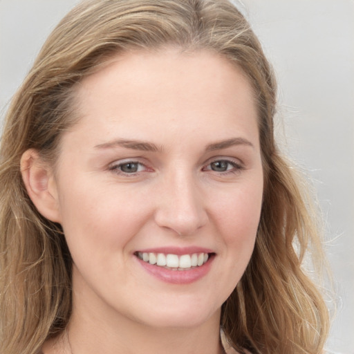 Joyful white young-adult female with long  brown hair and grey eyes