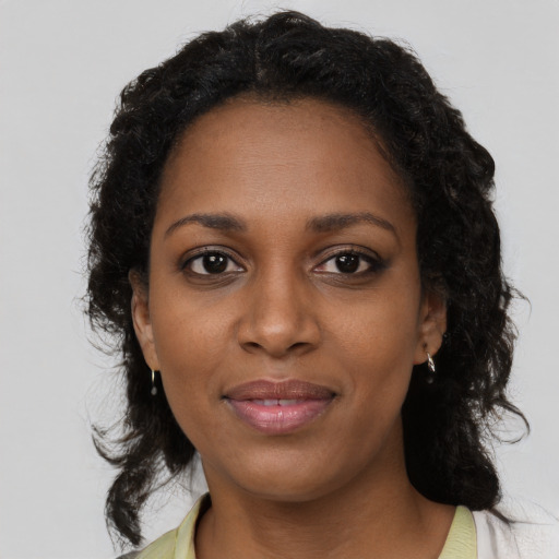 Joyful black young-adult female with medium  brown hair and brown eyes