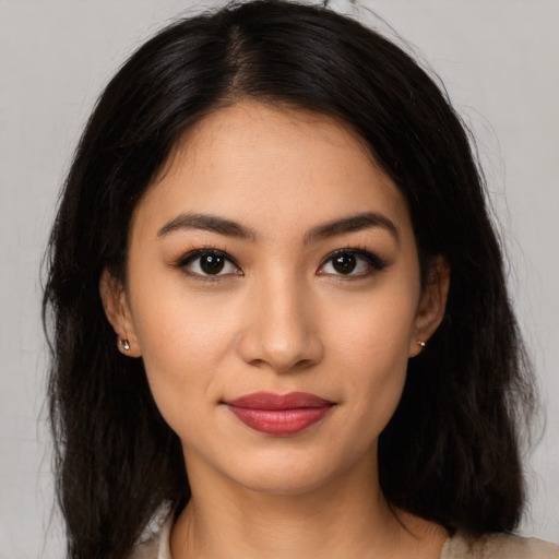 Joyful latino young-adult female with long  brown hair and brown eyes