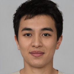 Joyful asian young-adult male with short  brown hair and brown eyes