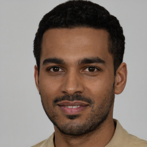 Joyful black young-adult male with short  black hair and brown eyes