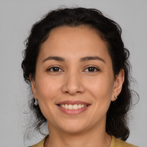 Joyful latino young-adult female with medium  brown hair and brown eyes