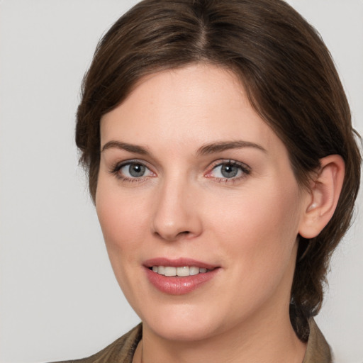 Joyful white young-adult female with medium  brown hair and grey eyes