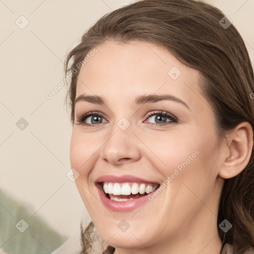 Joyful white young-adult female with medium  brown hair and green eyes