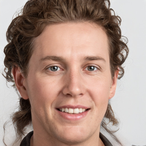 Joyful white young-adult male with medium  brown hair and grey eyes