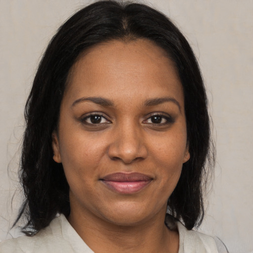 Joyful black adult female with medium  brown hair and brown eyes