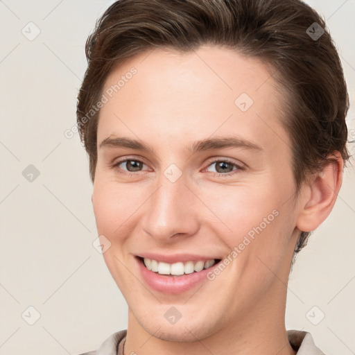 Joyful white young-adult female with short  brown hair and grey eyes