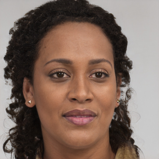 Joyful black adult female with long  brown hair and brown eyes