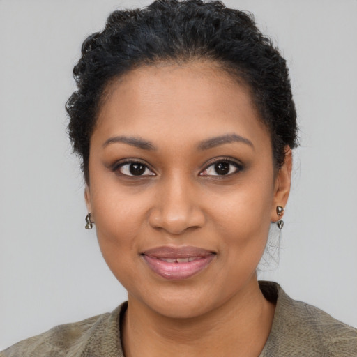 Joyful black young-adult female with short  black hair and brown eyes
