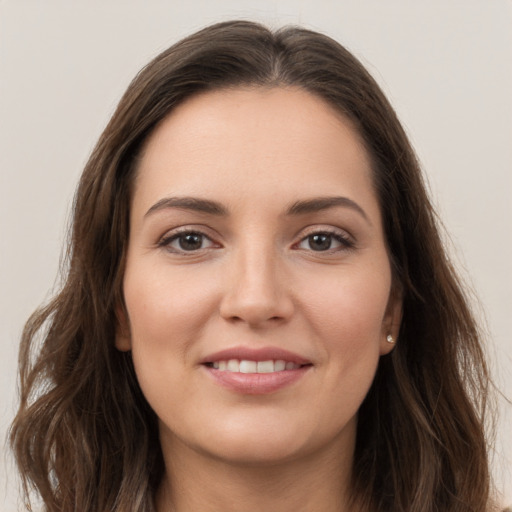 Joyful white young-adult female with long  brown hair and grey eyes