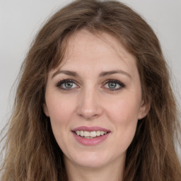 Joyful white young-adult female with long  brown hair and green eyes