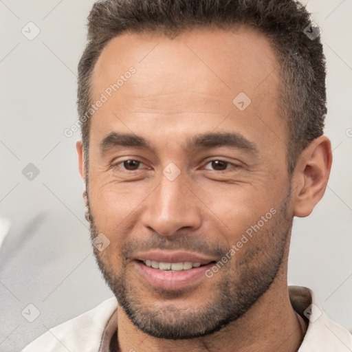 Joyful white adult male with short  brown hair and brown eyes