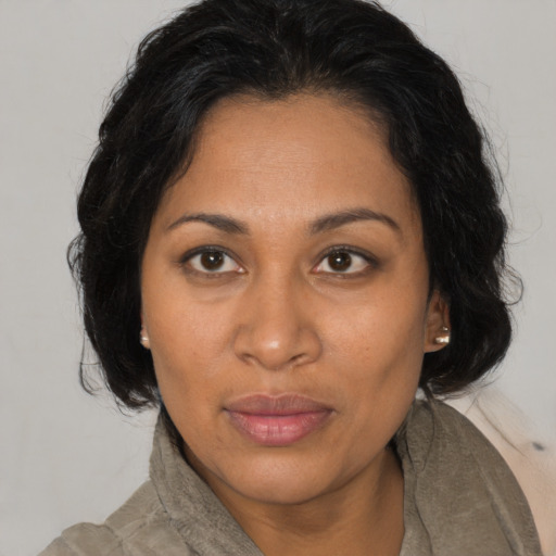 Joyful black adult female with medium  brown hair and brown eyes