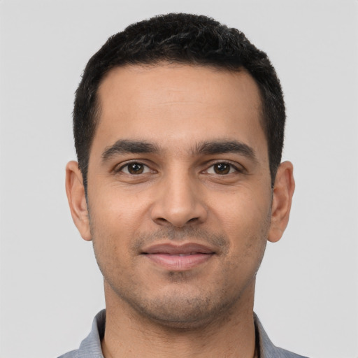 Joyful latino young-adult male with short  black hair and brown eyes