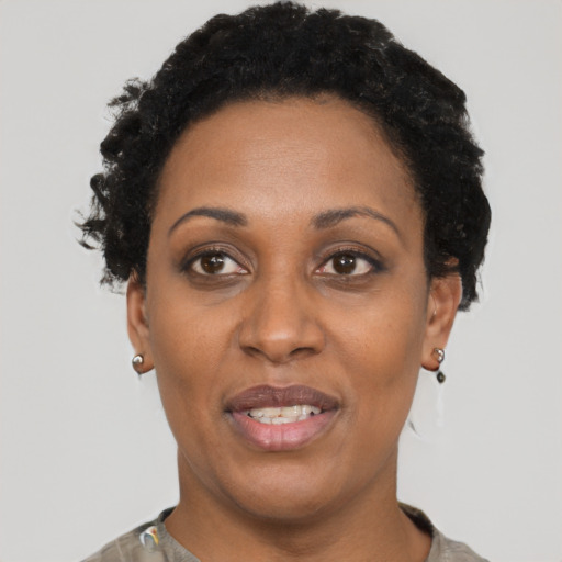 Joyful black adult female with short  black hair and brown eyes