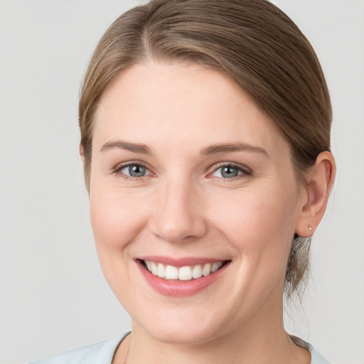 Joyful white young-adult female with medium  brown hair and grey eyes