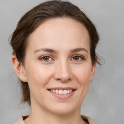 Joyful white young-adult female with medium  brown hair and grey eyes