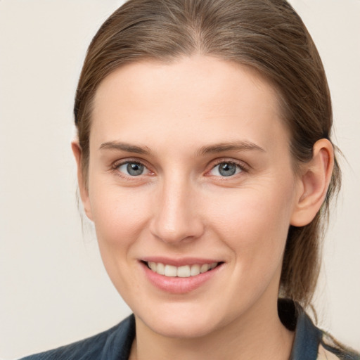 Joyful white young-adult female with medium  brown hair and grey eyes