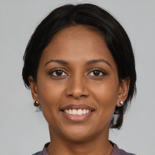 Joyful black young-adult female with medium  brown hair and brown eyes
